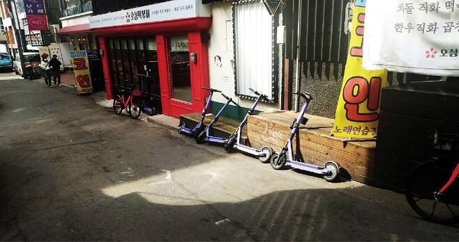 킥보드와 자전거가 가게 앞에 주차돼 상인에게 피해를 주는 경우도 적지 않았다.[사진=더스쿠프 포토]