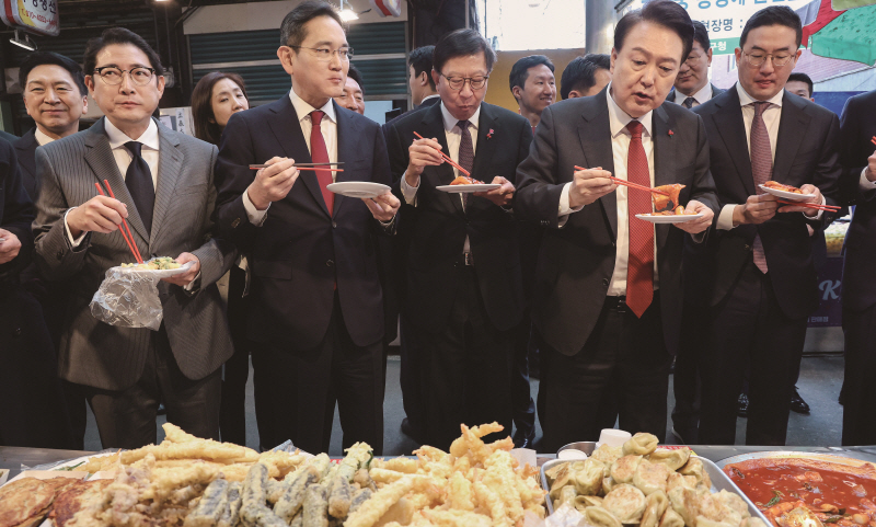 윤석열 대통령은 지난 6일 대기업 총수들과 함께 부산 중구 깡통시장을 찾아 떡볶이를 나눠 먹었다.[사진=연합뉴스]