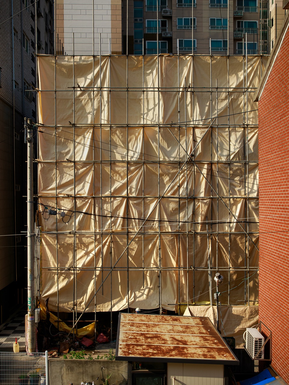 본격적인 해체공사를 앞두고 설치한 먼지비산방지망(누런 천). 이제 천 뒤에서 건물이 조금씩 사라질 것이다. [사진=오상민 작가]
